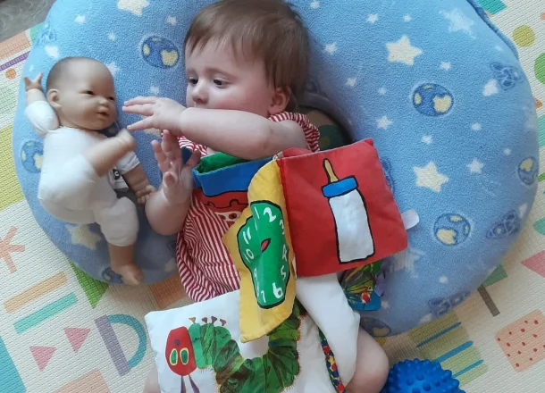 Child laying with doll in Langhorne, PA.